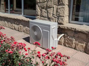 unite-exterieure-pompe-chaleur-air-air-fleurs-mur-pierre
